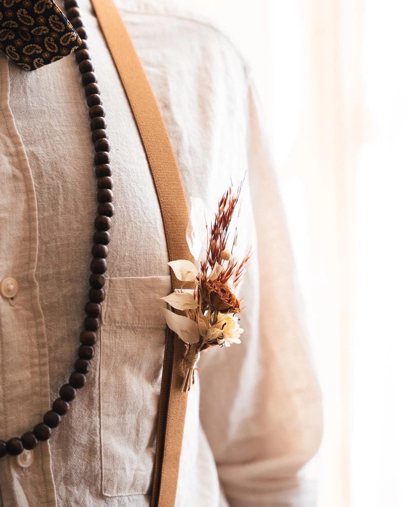 Boutonnière en fleurs séchées sur une veste en lin