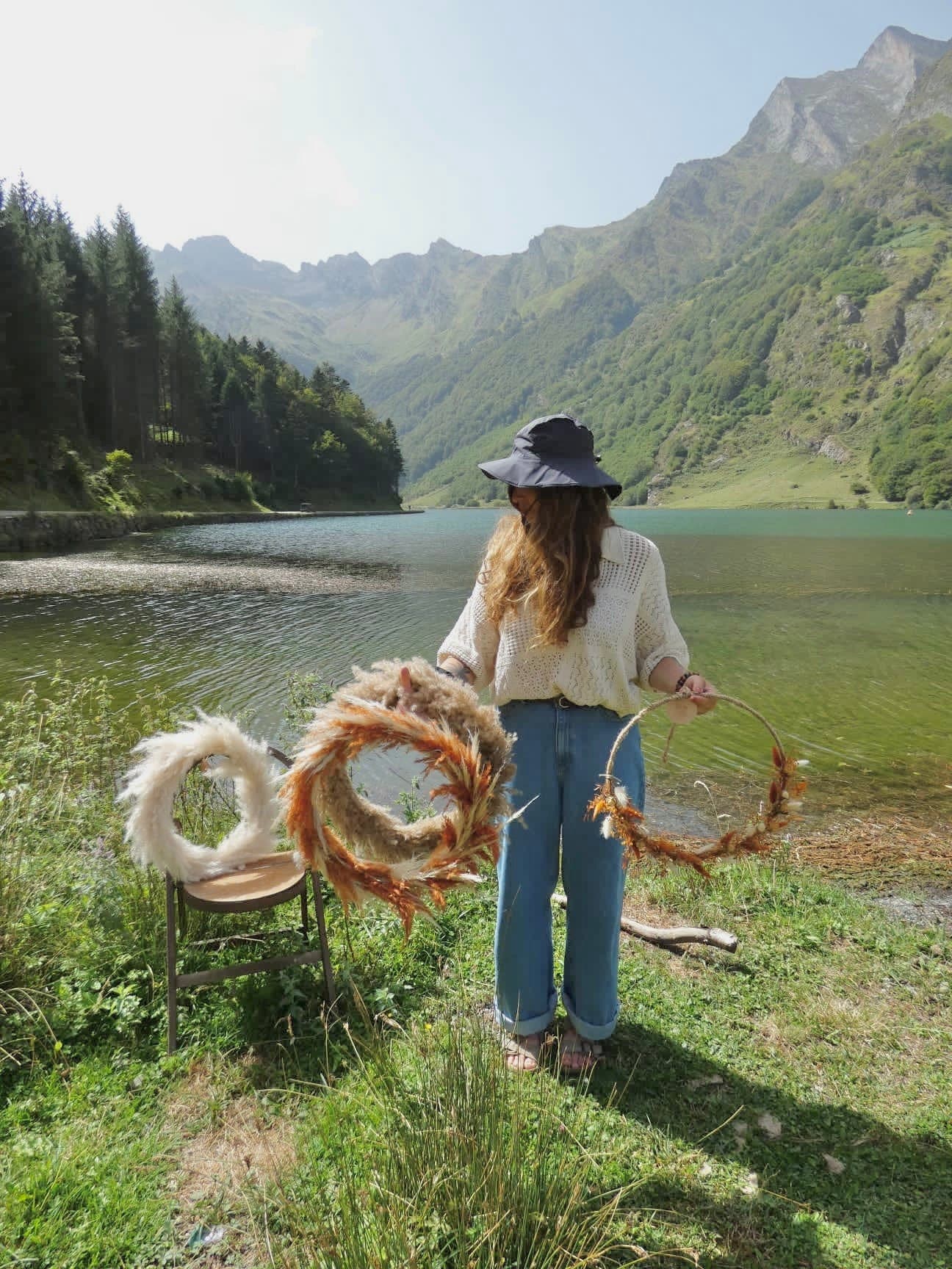 L'artisane de Cueillette avec ses couronnes de fleurs séchées, au bord d'un lac des Hautes-Pyrénées