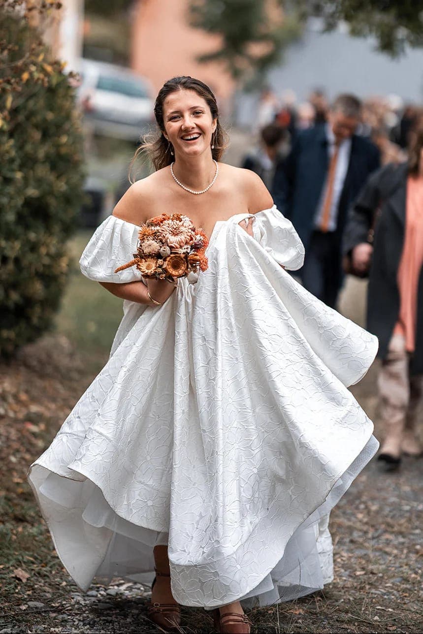 Mariée souriante tenant son bouquet de fleurs séchées